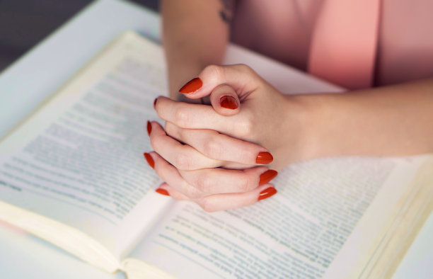 这就是祷告、信心和敬拜的观念。有两只手牵着对方。照片中的人正在读圣书。图片下载