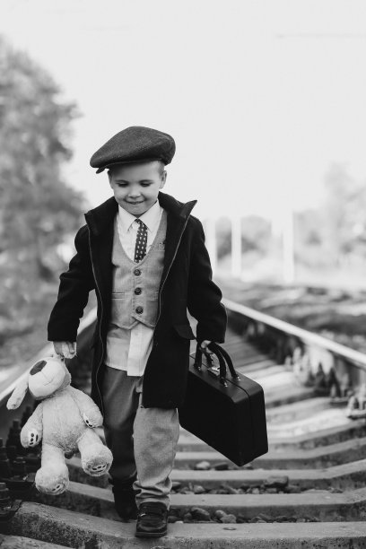 黑白复古照片，一个孩子带着行李箱走在枕边图片下载