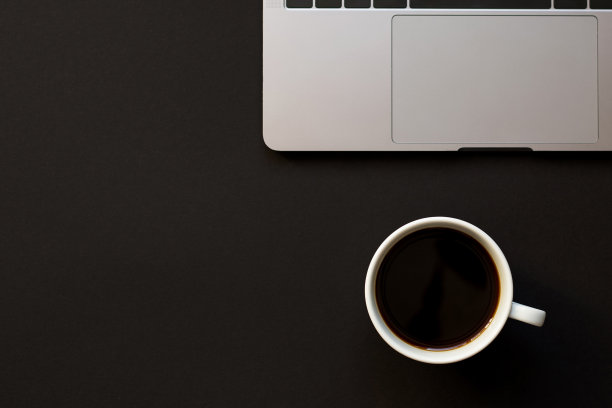 一张黑色的桌子，一台笔记本电脑和一杯咖啡。图片下载