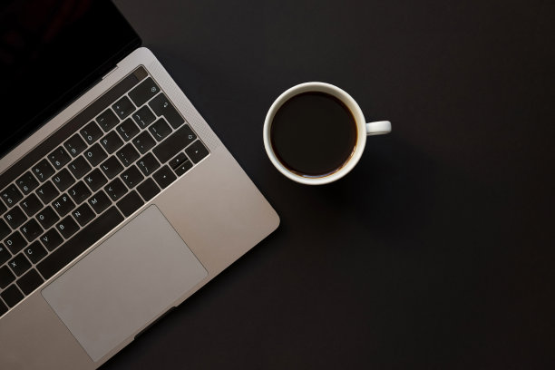 一张黑色的桌子，一台笔记本电脑和一杯咖啡。图片下载