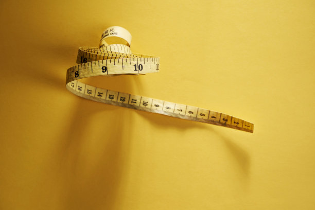 黄色卷尺在黄色背景上测量图片下载