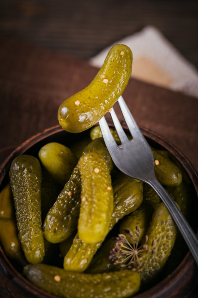 在木桌上放腌黄瓜、调味料和大蒜。健康的发酵食品。蔬菜罐头。图片下载