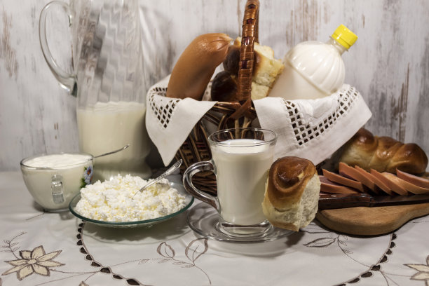 桌子上有一篮子面包、香肠和一瓶牛奶。附近有奶制品图片下载
