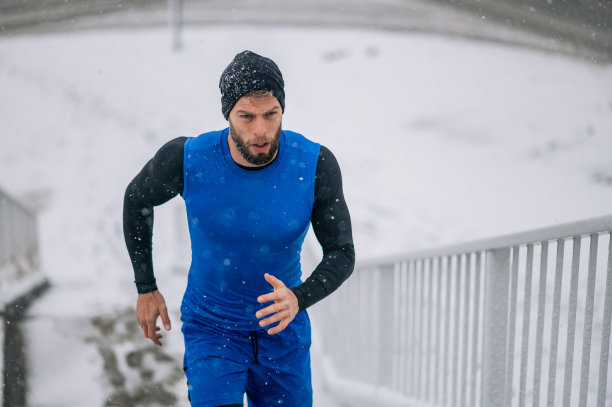 一个男人在寒冷的冬天在楼梯上奔跑。图片下载