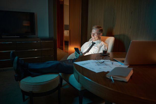 在昏暗的旅馆房间里，商人躺在扶手椅上图片下载