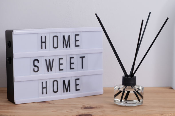 木桌上的灯箱上有文字HOME SWEET HOME和香苇扩散器图片下载