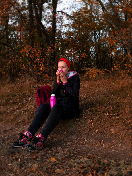旅行者女孩喝草药茶在山上森林景观徒步旅行。千禧女游客用杯子喝热咖啡图片下载