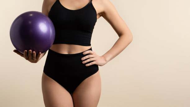 不知名的运动女人拿着普拉提球图片下载