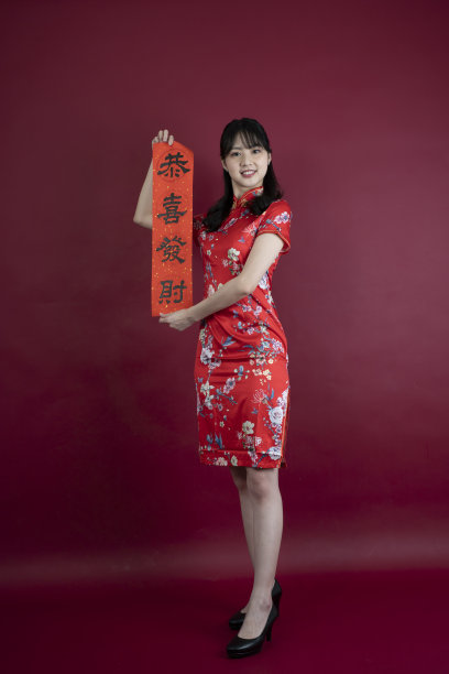 快乐的亚洲年轻女子展示红包庆祝中国新年图片下载