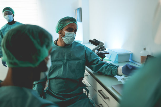 穿着防护服在化验室医院工作的医务人员-集中注意力在中心医生的脸上图片下载