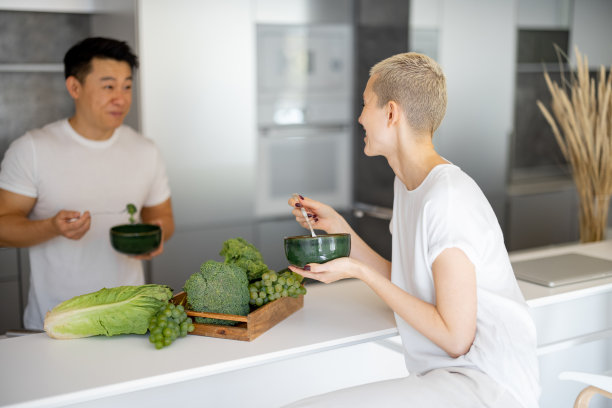 多种族夫妇在家里厨房吃沙拉图片下载