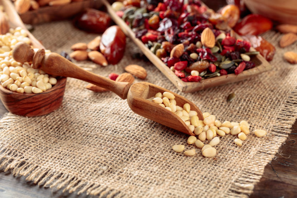 木桌上放着各种坚果和种子。图片下载