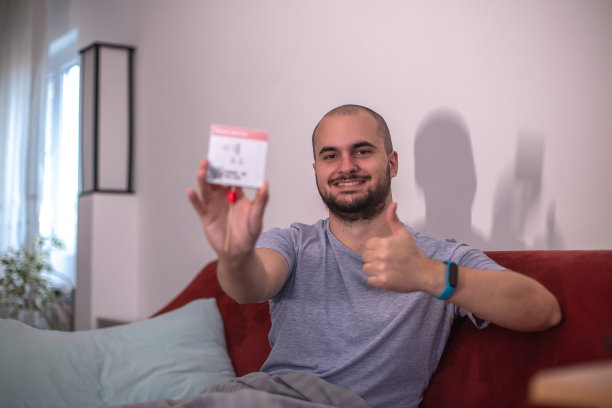 一名年轻男子在家用抗原试剂盒进行冠状病毒covid-19自我检测图片下载