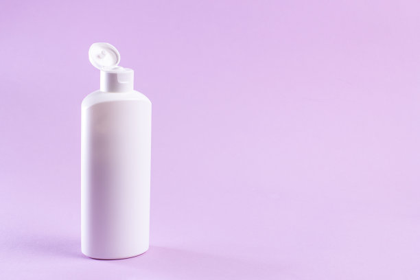 白色塑料瓶奶油没有标签在紫丁香背景。图片下载