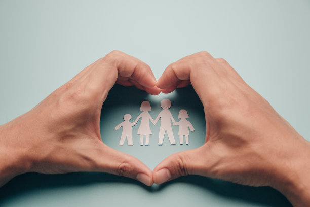 纸家庭在心手上蓝色的背景。图片下载