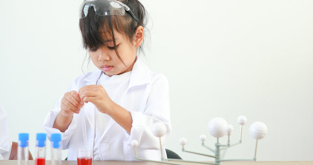 小女孩亚洲可爱的小学生学习研究和做化学实验，在家里的桌子上用试管分析和混合液体。图片下载