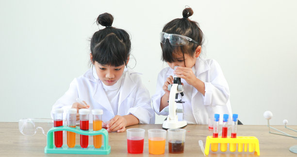 小女孩亚洲可爱的小学生学习研究和做化学实验，在家里的桌子上用试管分析和混合液体。图片下载