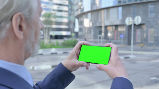 老人在户外用彩色屏幕看智能手机图片下载