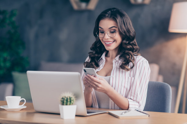 有趣的照片漂亮的年轻女士，穿白衬衫，眼镜打字现代小玩意，坐的桌子在室内房间家里图片下载