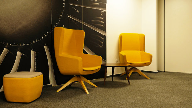 客厅现代室内设计中的两把黄色翼背椅。室内设计一个休闲的会议区域在现代公司办公室，等候室或共同工作空间。图片下载