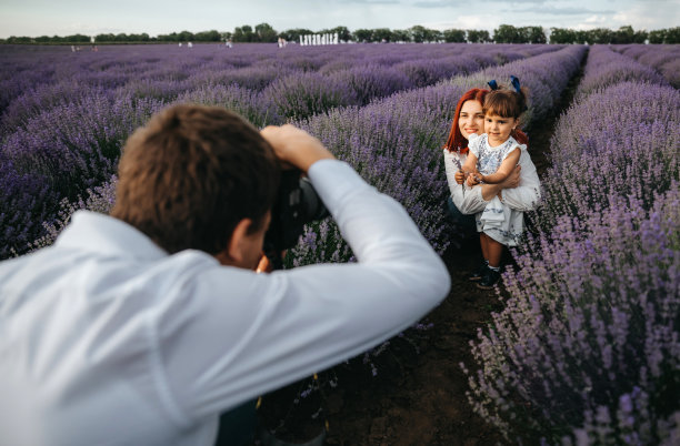 摄影师正在给一位年轻女子和她的女儿拍照图片下载