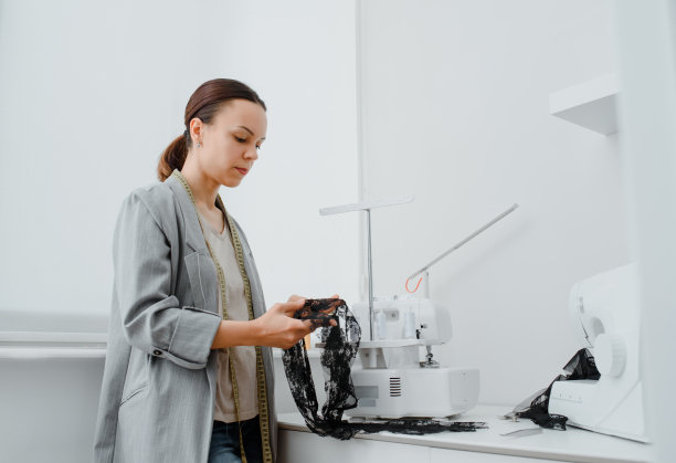 年轻的女针线匠正在准备面料的花边图片下载