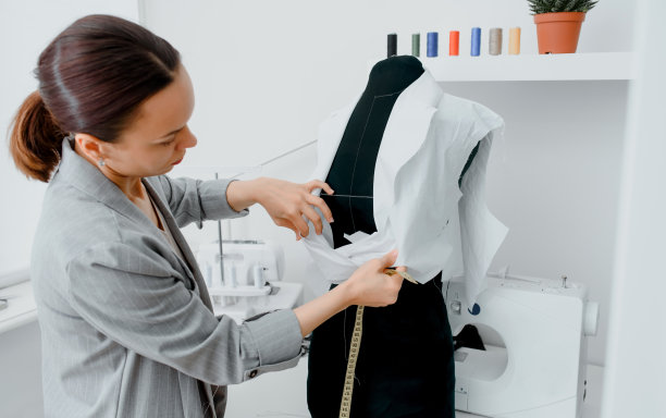 年轻的女裁缝正在用一条厘米长的缎带量一件未来的衬衫图片下载