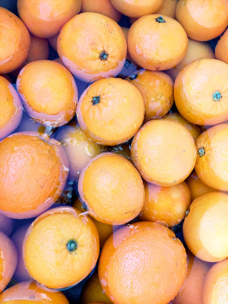 美丽的背景亮橙色的水。前视图。蓝光的反射。水果壁纸的设计和柑橘的概念图片下载