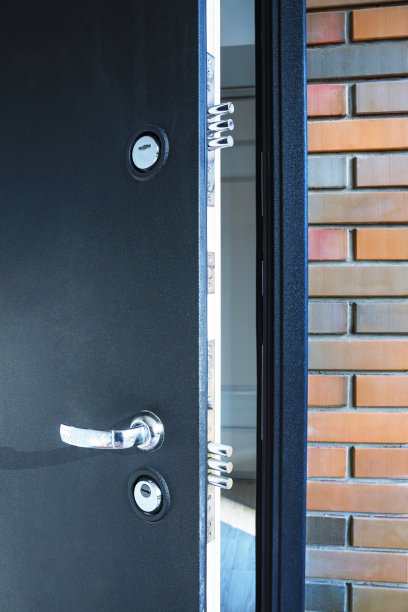 微微打开的前门上有两把锁，安全概念，特写，垂直图片下载