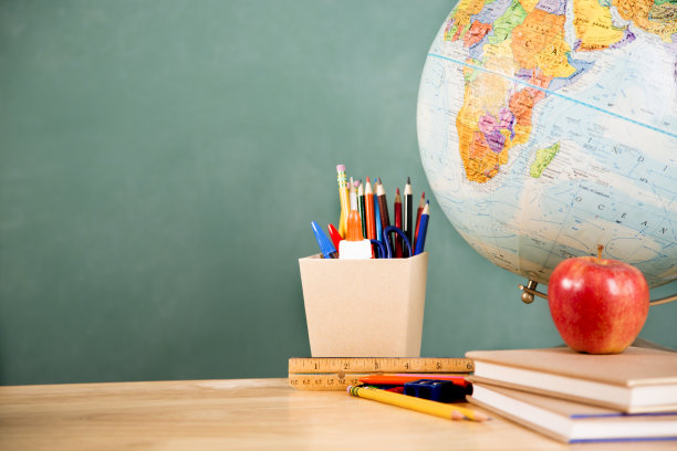 回到学校。学习用品，地球仪放在桌上。教育。图片下载