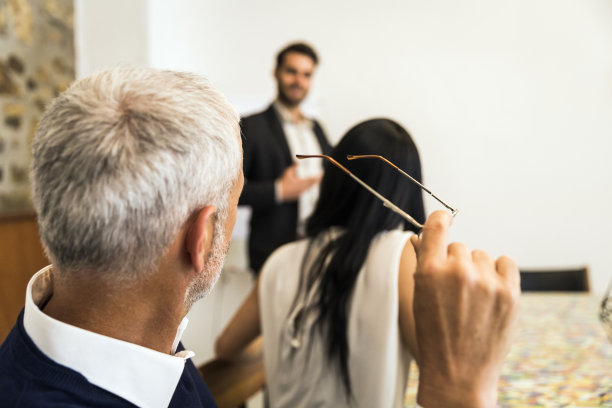 一位主管拿着眼镜看着同事图片下载