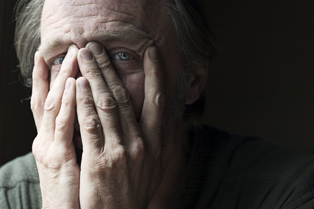 白人男子用手遮住脸，露出眼睛图片下载