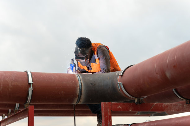 带保护面罩的焊工进行焊接工作图片下载