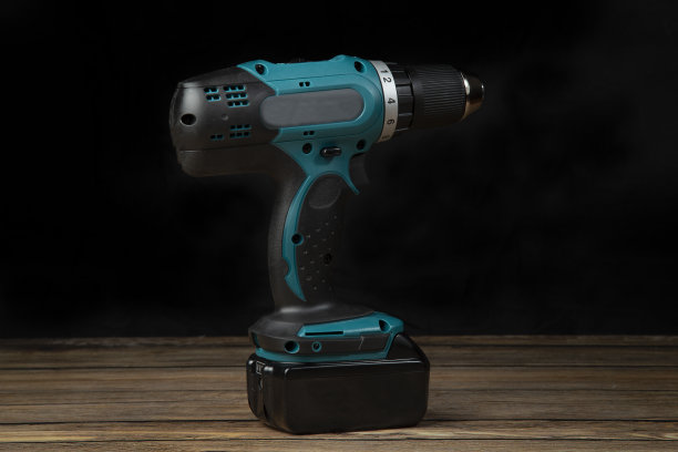 黑色背景上的电池钻螺丝刀。图片下载