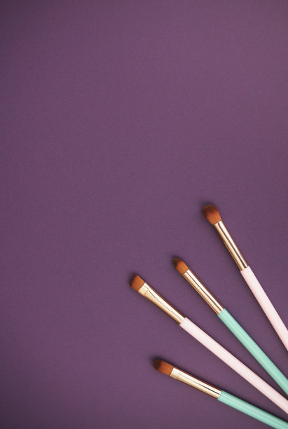 集合在充满活力的紫色背景上的化妆笔刷与复制空间。俯视图片下载