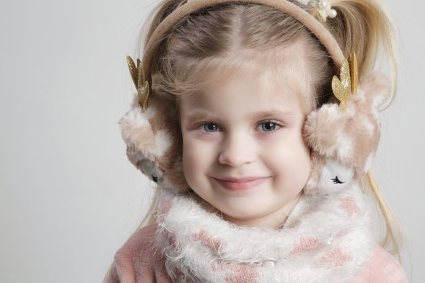 可爱的小女孩戴耳套和舒适的围巾的肖像。孩子们的冬季时尚。图片下载