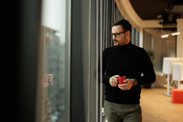 严肃的成人经理，一边喝着咖啡，一边凝视着窗外。图片下载