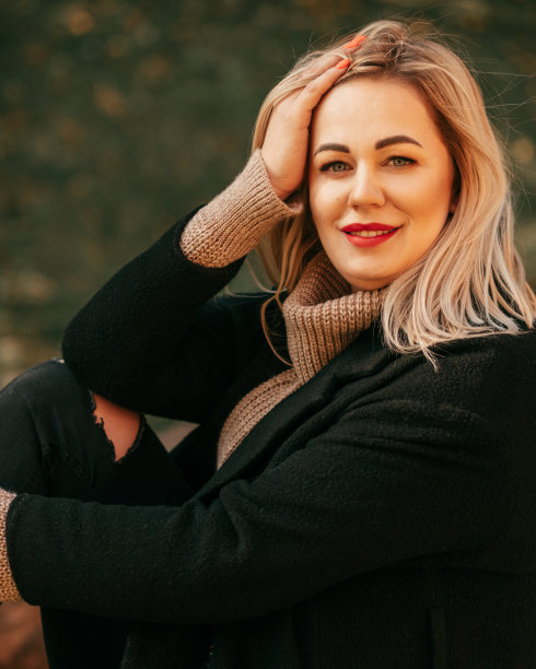 冷静，美丽的金发，涂着红色的口红，穿着优雅的秋装，微笑着在镜头前摆姿势。小生意。漂亮的女人。秋天的肖像。娱乐和旅游。图片下载