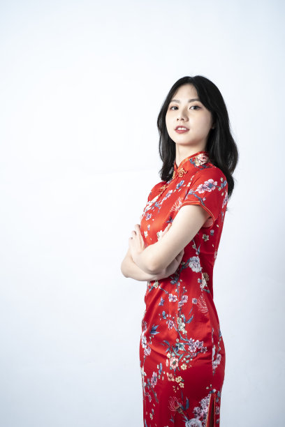 快乐亚洲年轻女子肖像，展示一个迷人和自信的微笑，拥抱胸部，看着你，图片下载