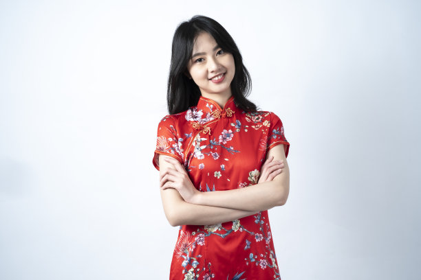 快乐亚洲年轻女子肖像，展示一个迷人和自信的微笑，拥抱胸部，看着你，图片下载