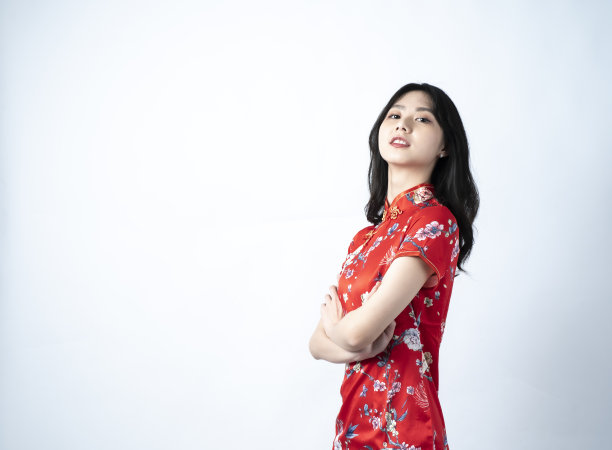 快乐亚洲年轻女子肖像，展示一个迷人和自信的微笑，拥抱胸部，看着你，图片下载