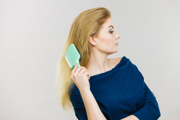 女人用刷子梳理她的长发图片下载