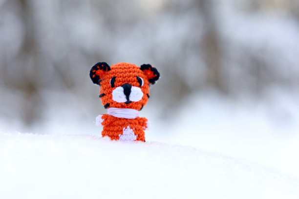 在森林的雪地上编织玩具老虎图片下载