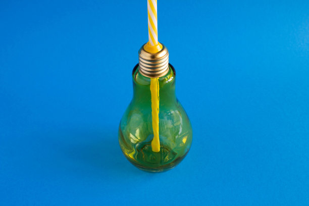 蓝色背景上灯泡形状的玻璃。特写镜头。副本的空间。图片下载