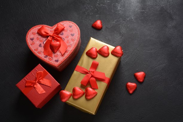 情人节爱情概念，甜蜜浪漫时刻，深色背景上的红色心形糖果图片下载