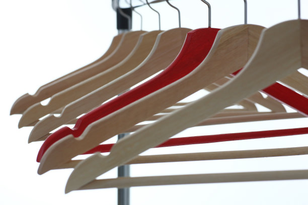 红色和木制衣架挂在金属管道上图片下载