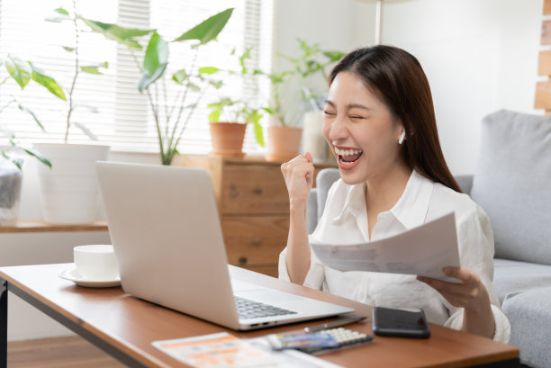 年轻的亚洲妇女感到高兴兴奋成功完成她的工作或考试。与同事和团队成员进行在线视频电话交流，并通过电子邮件传达消息。图片下载