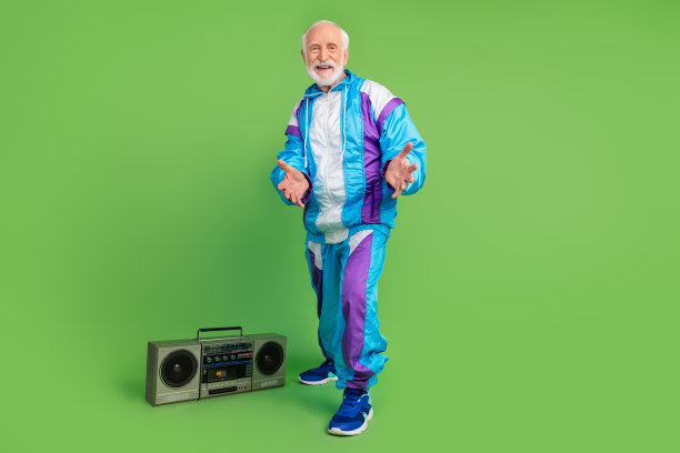 照片漂亮迷人的成熟的家伙穿着蓝色运动微笑听轰鸣声跳舞孤立的绿色背景图片下载