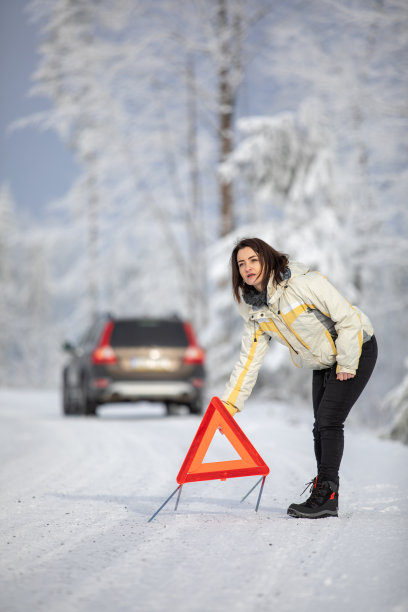 漂亮的年轻女人在车抛锚后摆出了一个三角警示牌图片下载