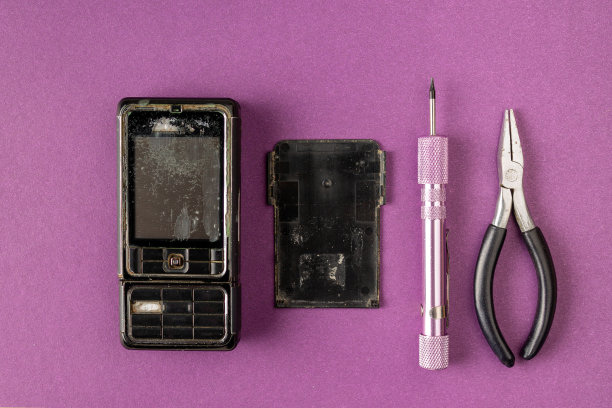 旧的破手机和修理工具在紫丁香背景图片下载